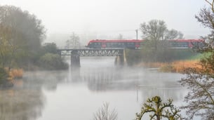 Trein op een spoorbrug in de mist