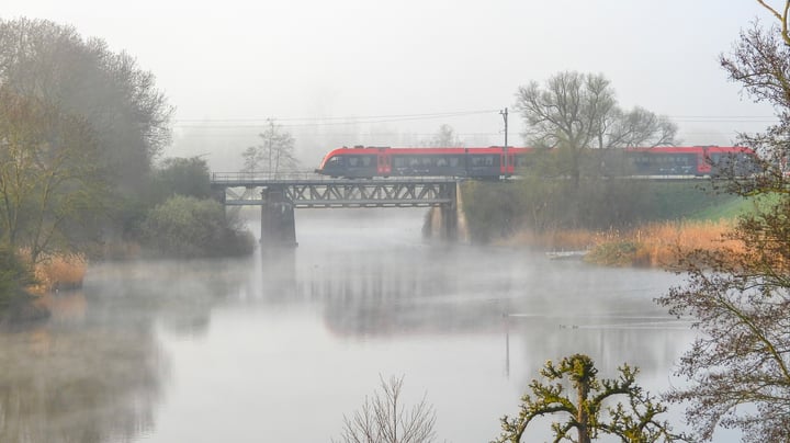 Trein op een spoorbrug in de mist